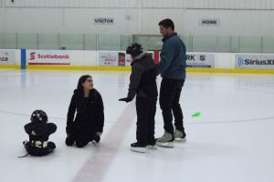 Two York University students helping young skaters on the ice